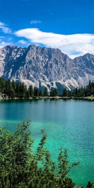 lake Scenic view of a beautiful lake surrounded by the majestic Dolomites in Italy, reflecting the mountains and sky.