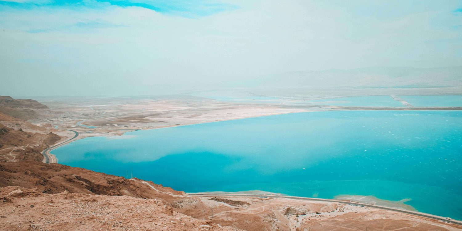 sea A panoramic view of the Dead Sea, a salt lake in Israel, showcasing its unique blue waters and surrounding arid landscape.
